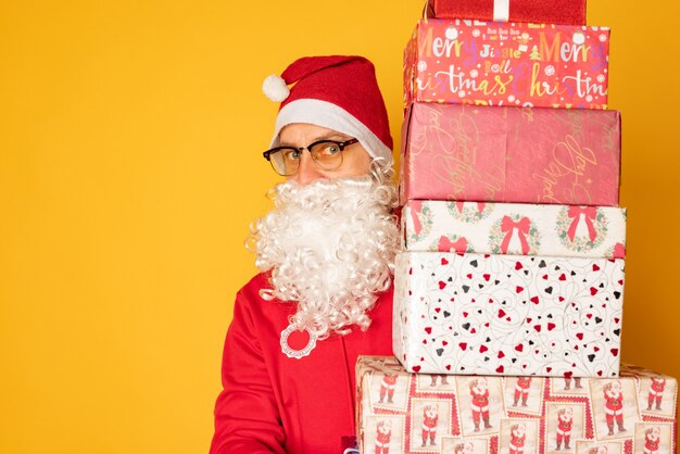 Papai noel trouxe presentes de natal. papai noel moderno em fundo amarelo