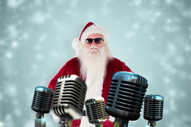 Papai Noel usa óculos de sol pretos contra um desenho de floco de neve branco em azul