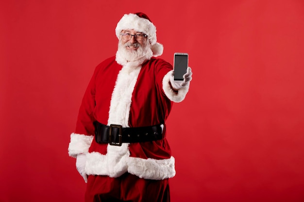 Papai Noel usando um telefone celular com fundo vermelho