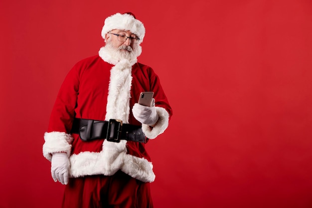 Papai Noel usando um telefone celular com fundo vermelho