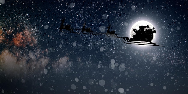 Papai Noel voa na véspera de Natal no céu noturno com neve