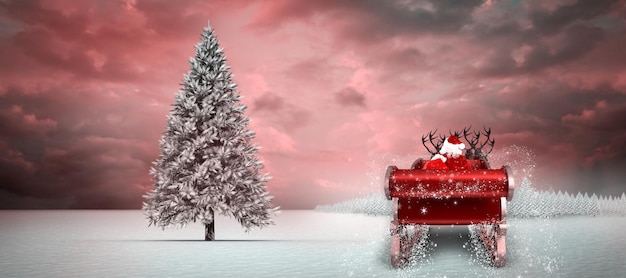 Papai Noel voando em seu trenó contra um pinheiro em paisagem de neve