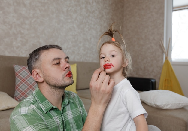 Papai pinta os lábios da filha com batom brilhante