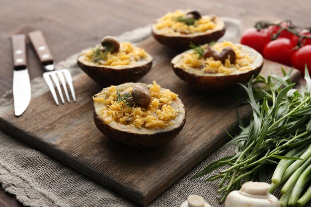 Papas al horno con queso y champiñones en la mesa de cerca