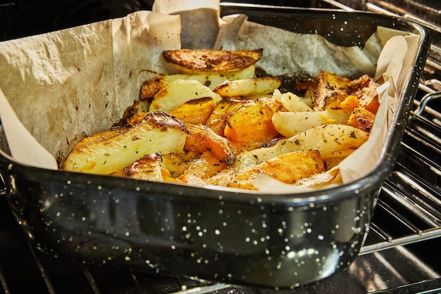 Foto las papas con batatas se hornean en el horno en una bandeja para hornear