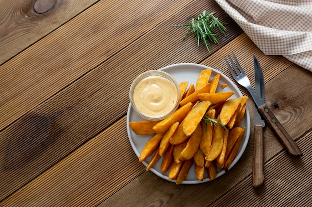 Papas fritas asadas con salsa y hierbas.