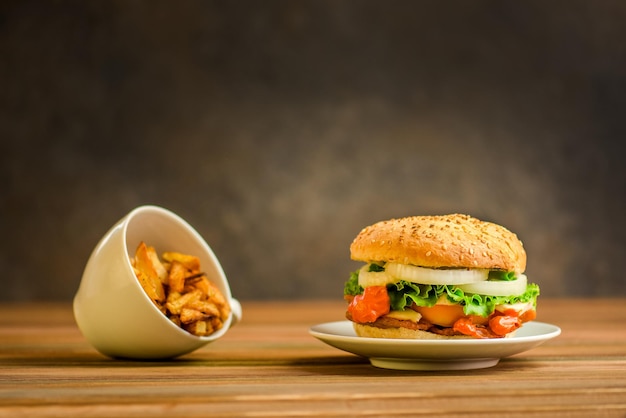 Papas fritas y burge delicioso y jugoso en un estilo rústico