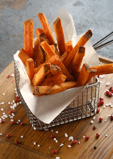 Foto papas fritas de camote en una tabla de madera