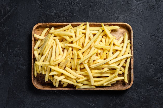 Papas fritas congeladas en un tazón de madera.