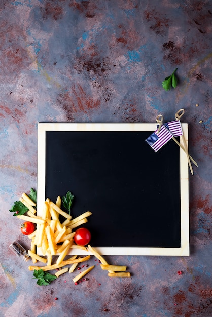 Foto papas fritas frescas en la pizarra