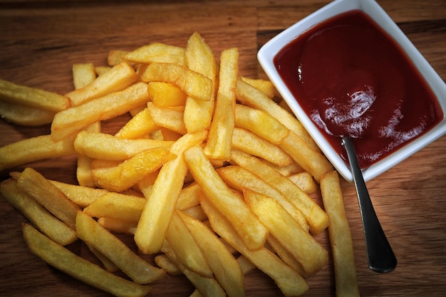 Papas fritas fritas con ketchup en una mesa de madera
