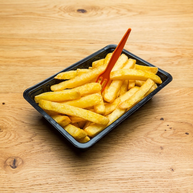 Papas fritas holandesas en una concha con tenedor