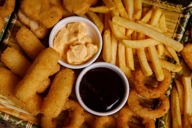 Foto papas fritas nuggets de pollo y pescado salsa de queso salsa bbq comida en el plato