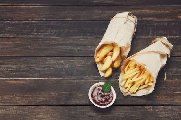 Papas fritas y papas en una mesa de madera