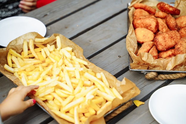 Papas fritas y pepitas en la mesa de madera.