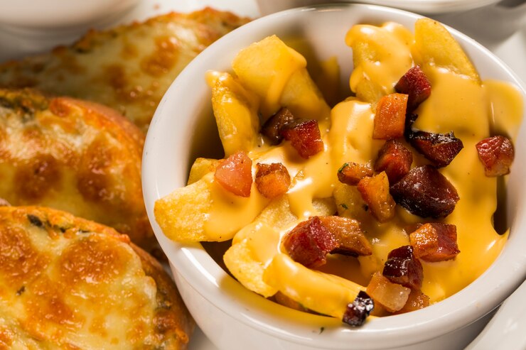 papas fritas con queso cheddar y tocino