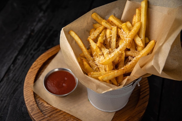 Papas fritas con salsa de tomate en una mesa de madera oscura