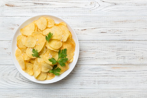 Papas fritas en un tazón con servilleta sobre fondo de color Deliciosas papas fritas crujientes en un tazón Espacio para texto Vista superior