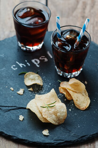 Papas fritas y un vaso de cola sobre la mesa