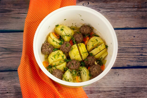 Foto papas guisadas con albóndigas en la olla de barro