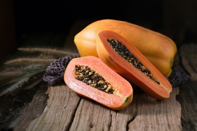 Papaya auf hölzernem Hintergrund. In Scheiben geschnitten von Papaya.