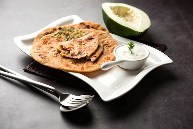 Foto papaya cruda paratha o papita ke parathe elaborado con papaya, harina de trigo, semillas de comino y jengibre. receta popular de comida india servida caliente con cuajada. enfoque selectivo