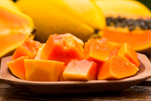 Papaya fresca en rodajas sobre mesa de madera