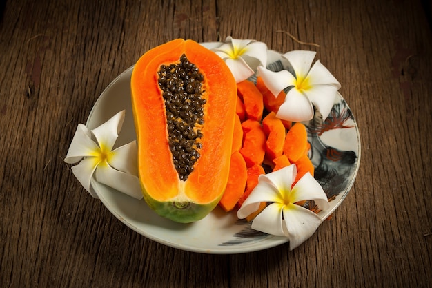 Papaya frisches Obst. auf dem Teller. auf altem Holz. Morgen. Sonnenuntergang wunderschön