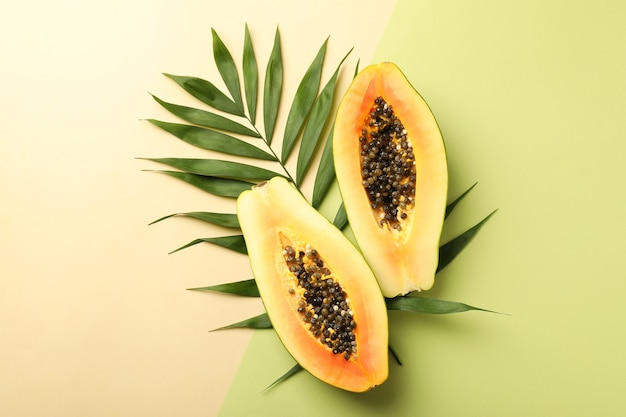 Papaya madura con hojas sobre fondo de dos tonos