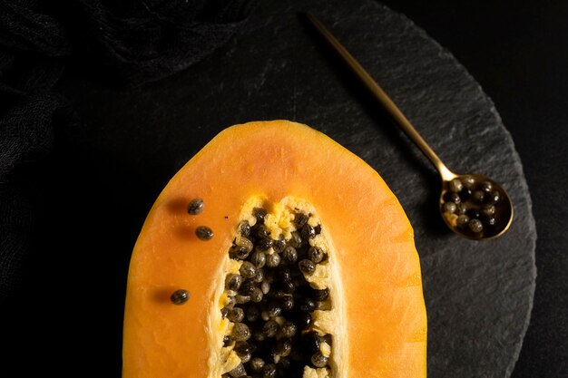 Papaya madura y recién cortada. Fruta fresca y tropical con fondo oscuro.