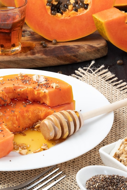 Papaya madura servida con granola, miel y semillas de chía.