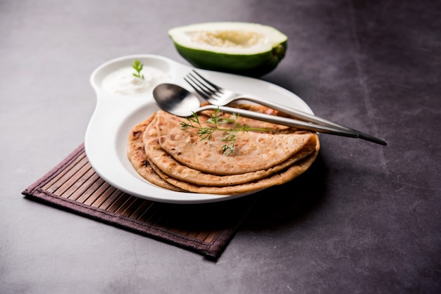 Foto papaya paratha crua ou papita ke parathe confeccionada com feito com mamão, farinha de trigo, sementes de cominho, gengibre. receita de comida indiana popular servida quente com requeijão. foco seletivo