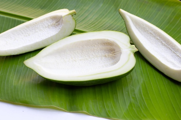 Papaya verde en hojas de plátano