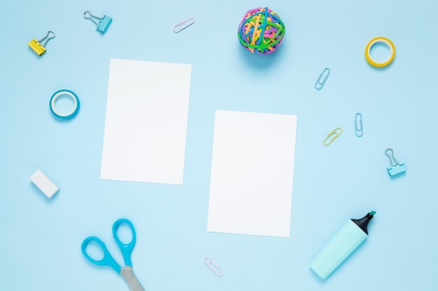 Papéis brancos de maquete e conjunto de artigos de papelaria para trabalho e estudo sobre fundo azul De volta à escola