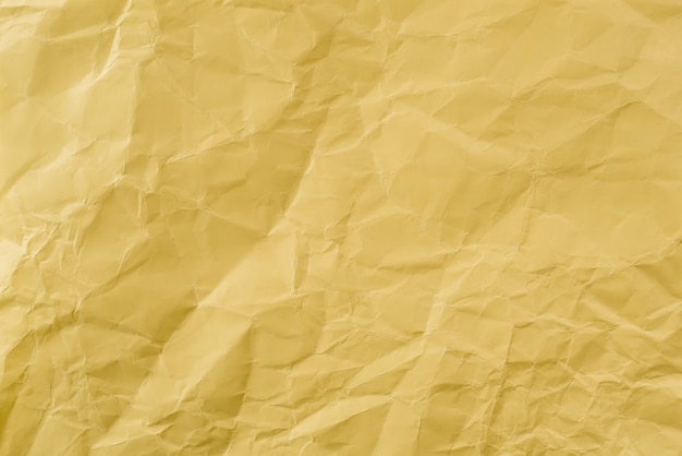 Papel amarelo amassado com textura macia. Plano de fundo simples.