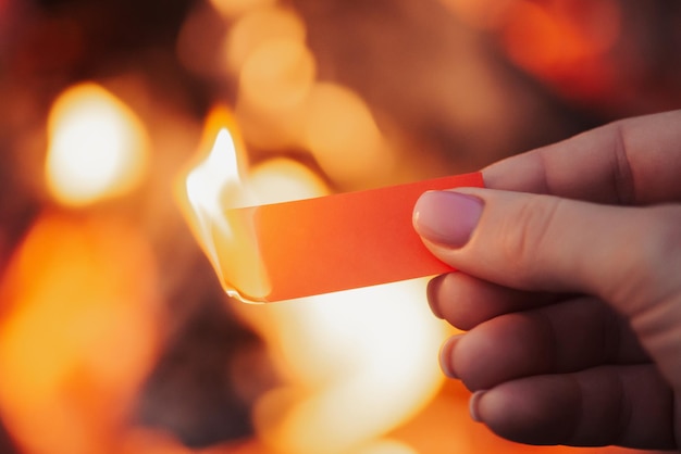 Papel ardente vermelho nas mãos de uma mulher com espaço vazio para inscrição fim de algo conceito de dificuldades de problemas