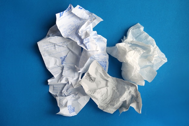 El papel arrugado es una especie de basura sobre un fondo azul simple El concepto de reciclaje de residuos