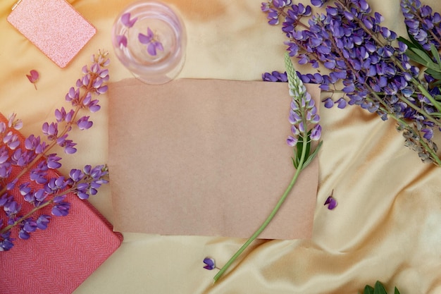 Papel artesanal maqueta natural Altramuces flores púrpuras decoraciones de copas de vino Invitación de verano tarjeta de cumpleaños Concepto del día de la madre Fondo vibrante femenino Concepto de bienestar cerca de la naturaleza