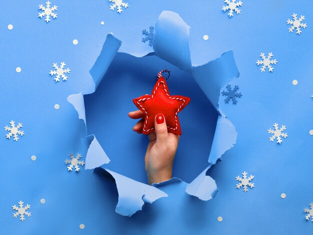 Papel azul plana leigos com flocos de neve e rasgado buraco no meio