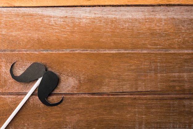 Papel de bigote negro sobre fondo de madera