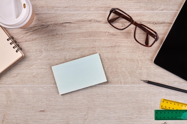 Papel en blanco para espacio de copia con gafas y herramientas de papelería de pluma en escritorio de madera y espacio de copia