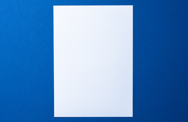 Papel en blanco sobre fondo azul vista superior