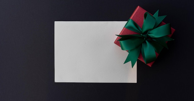 papel branco em branco com caixa de presente de Natal em fundo de cor em branco para design como cartão de felicitações
