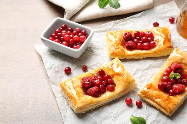 Papel de comida con deliciosos pasteles en mesa de madera.