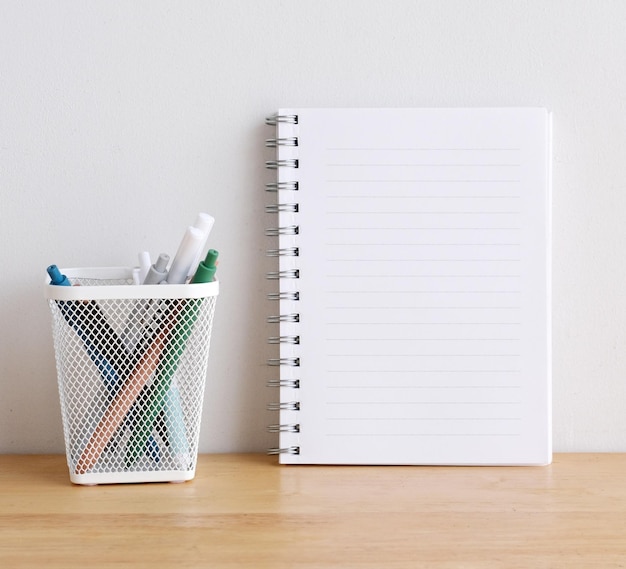 Papel de cuaderno en blanco sobre plantilla de maqueta de fondo de mesa de madera