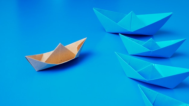 Papel de barco de origami de conceito de liderança