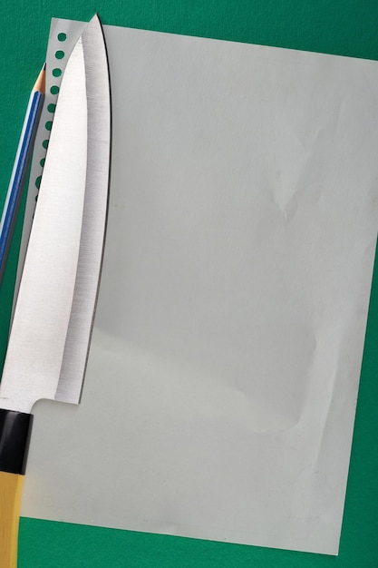Papel de nota em branco com faca de cozinha e lápis