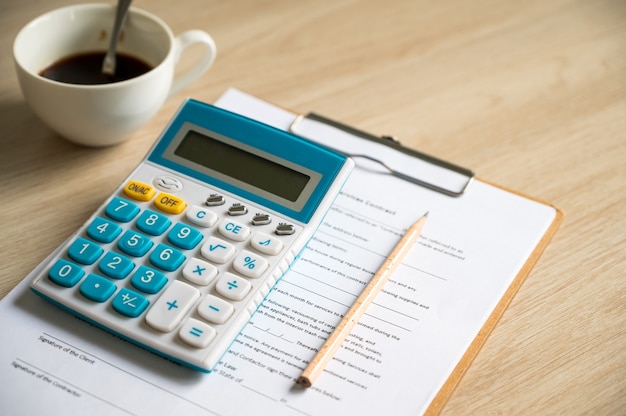 Papel de relatório financeiro e máquina de cálculo na mesa de mesa de escritório, conceitos de finanças e contabilidade