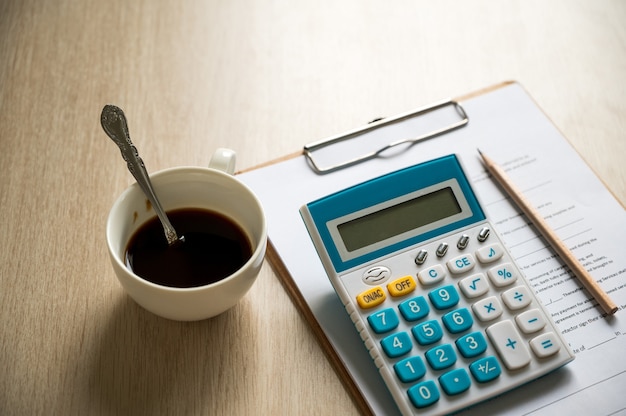 Papel de relatório financeiro e máquina de cálculo na mesa de mesa de escritório, conceitos de finanças e contabilidade