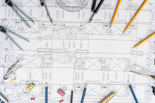 Papel con dibujos técnicos y herramienta de trabajo sobre mesa. lugar de trabajo